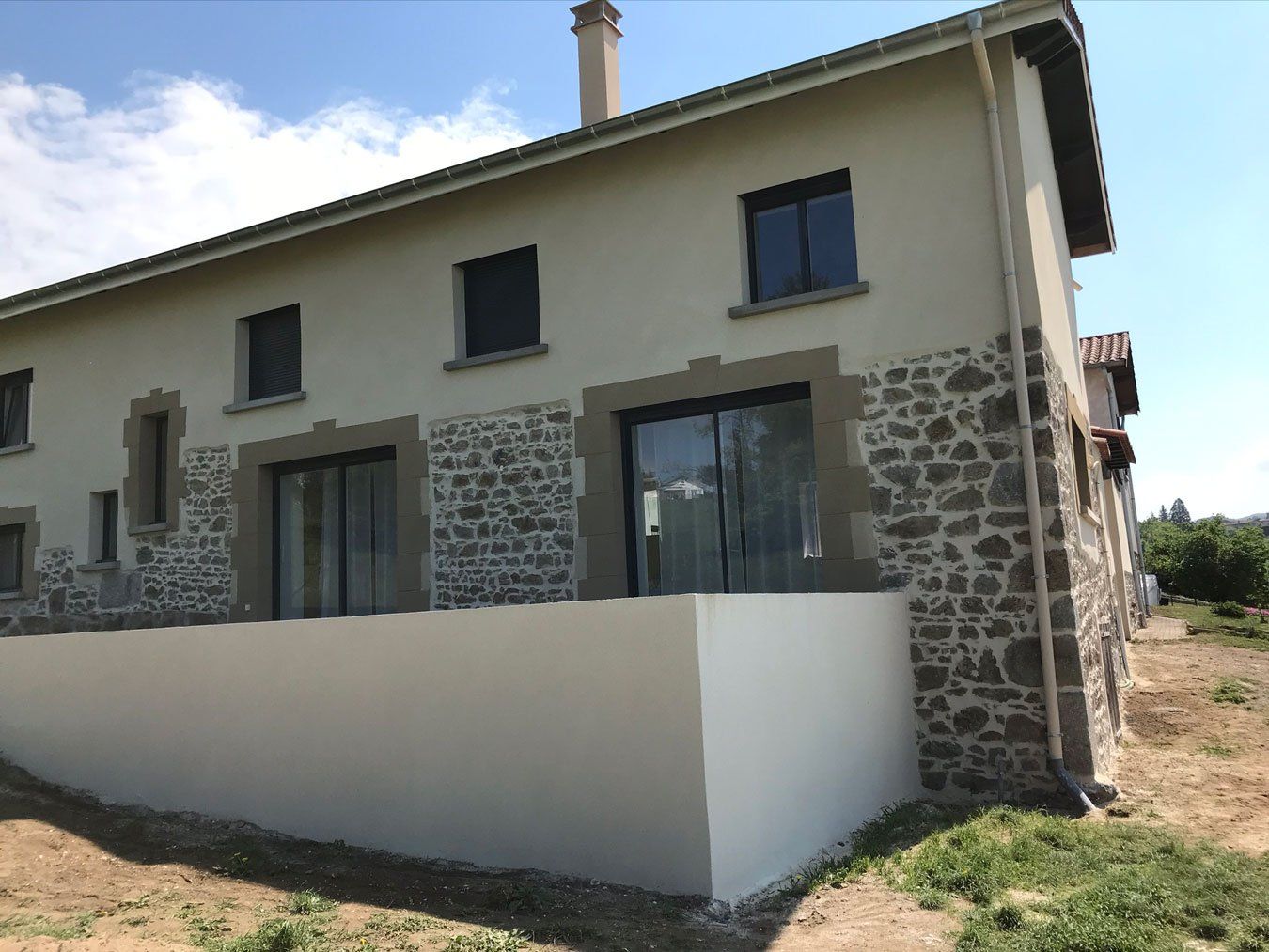 Maison avec deux portes-fenêtres et un muret blanc