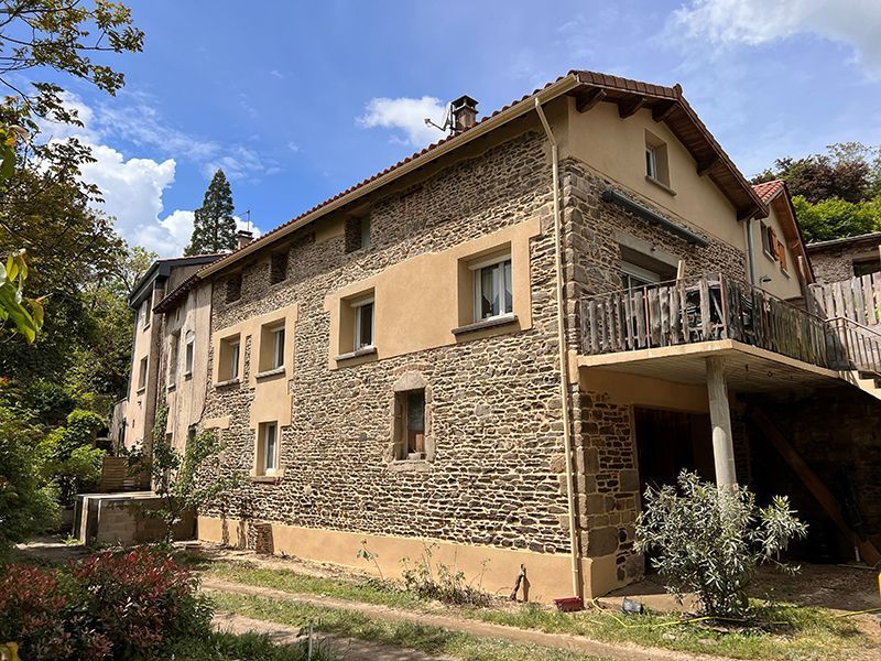 Maison avec façade en mur de pierres avant ravalement et peinture des encadrements couleur ocre