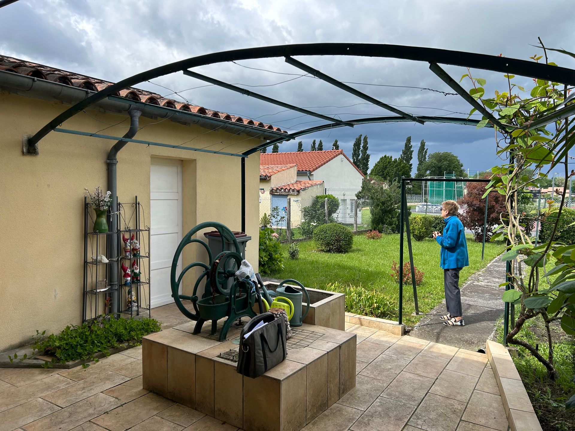 un homme debout devant une maison avec un tuyau