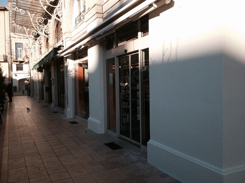 une rue avec un bâtiment blanc et un panneau