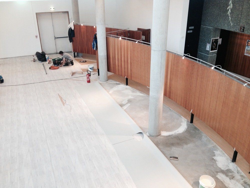 une pièce avec du parquet et un sol blanc