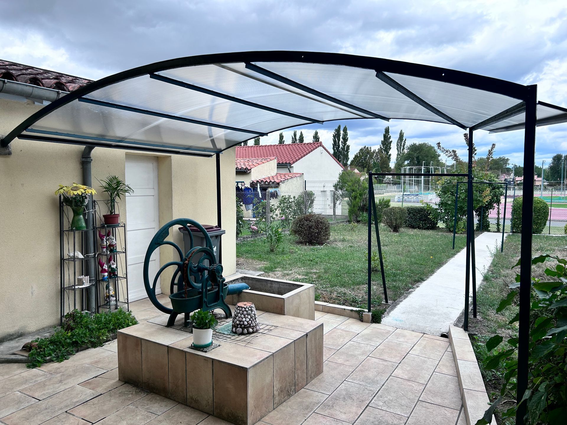 un patio avec une grande roue et une jardinière