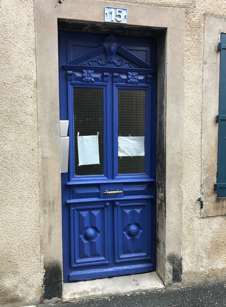 une porte bleue au milieu d'une rue