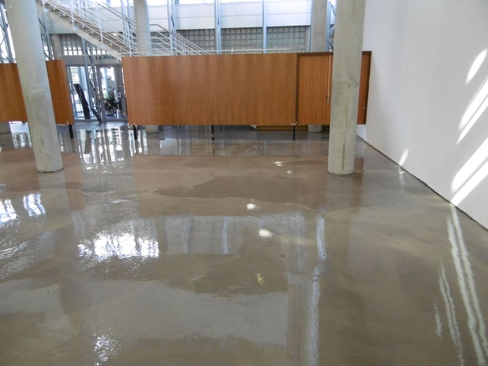 une grande pièce avec un sol en béton et un mur en bois