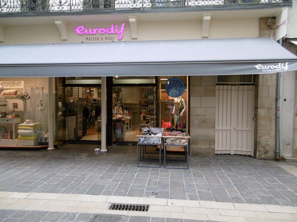 Une devanture de magasin avec un auvent blanc.