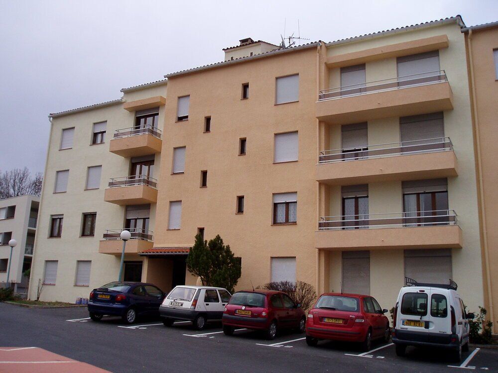 un immeuble avec des voitures garées devant