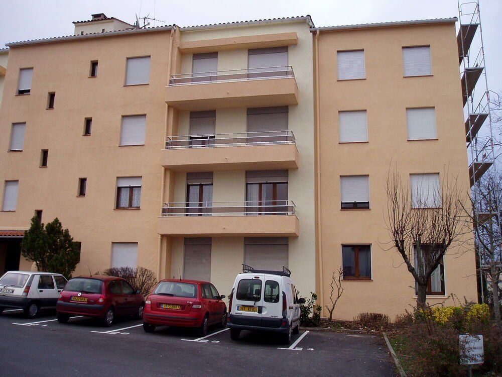 un immeuble avec des voitures garées devant