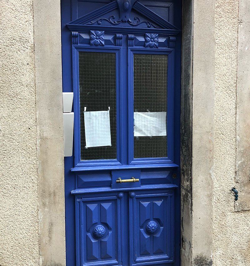 Une porte bleue avec une pancarte dessus.