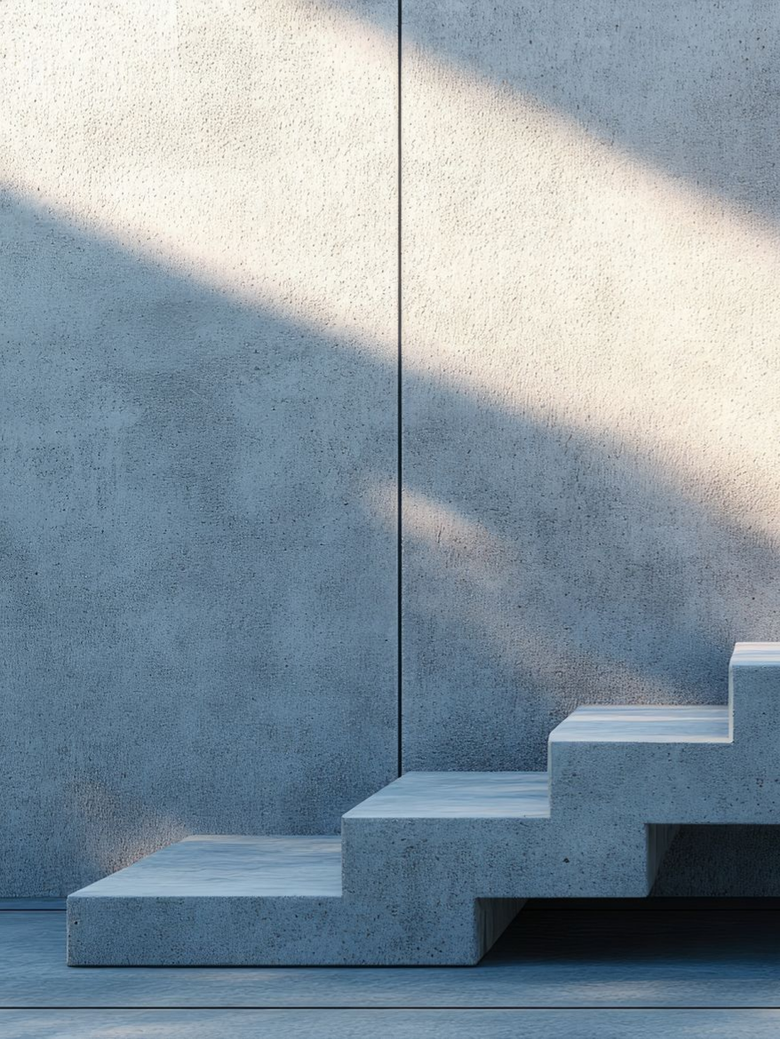 Marches en béton contre un mur texturé, illuminées par la lumière du soleil.
