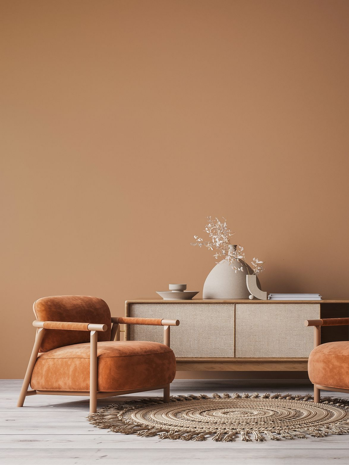 Salon confortable avec chaises orange, armoire tissée, tapis rond et murs beiges.
