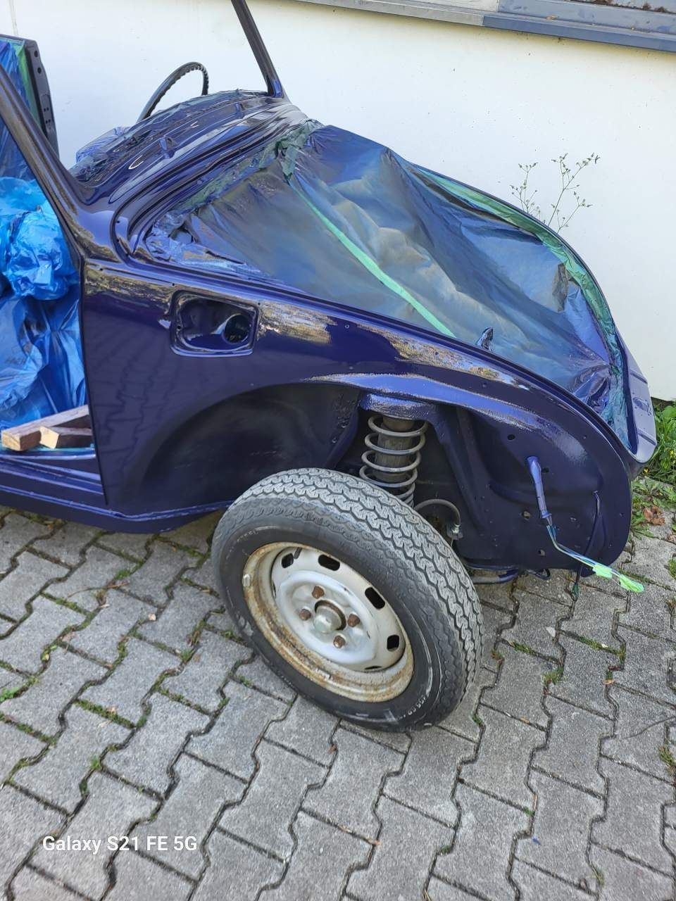 Blauer Autorahmen mit einem Reifen, im Freien.