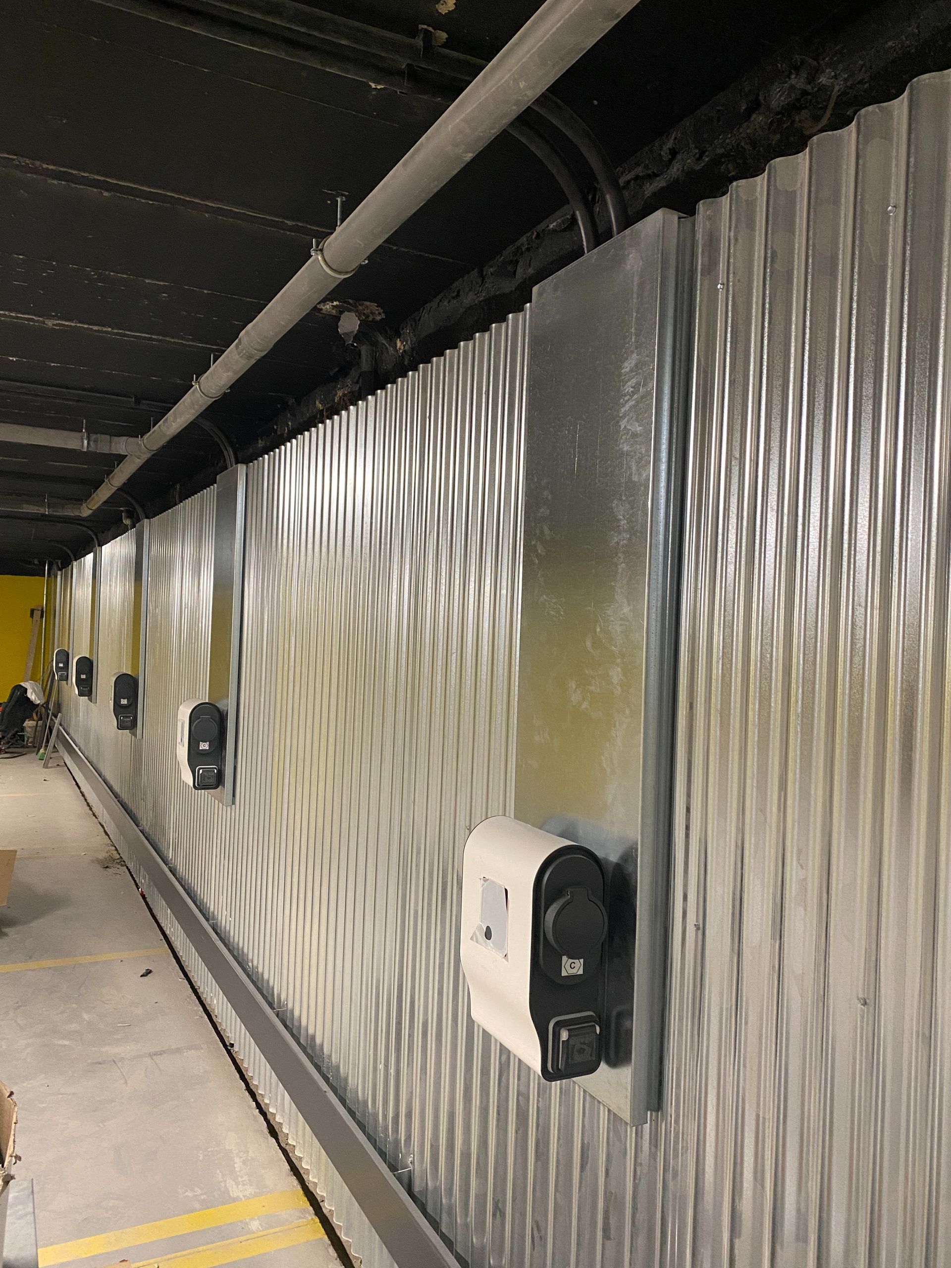 Una pared larga con muchos dispensadores de jabón.