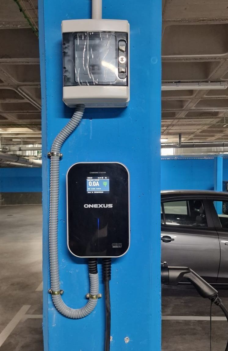 Un coche se está cargando en una estación de carga en un estacionamiento.