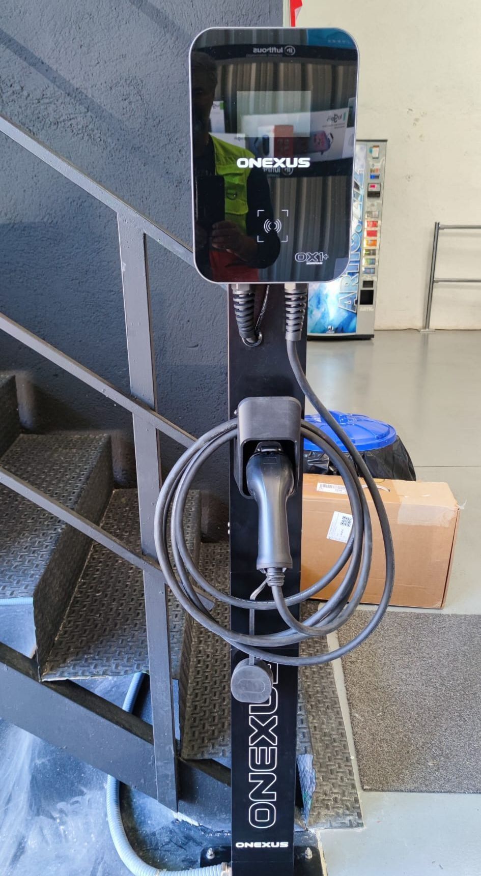 Una estación de carga para un vehículo eléctrico está situada al lado de una escalera.