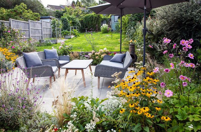 Terrasse en dalles de pierre au milieu de fleurs