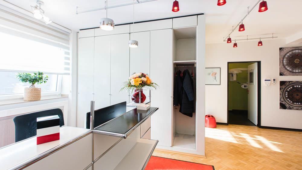 Ein Empfangsbereich mit Theke und einer Blumenvase.