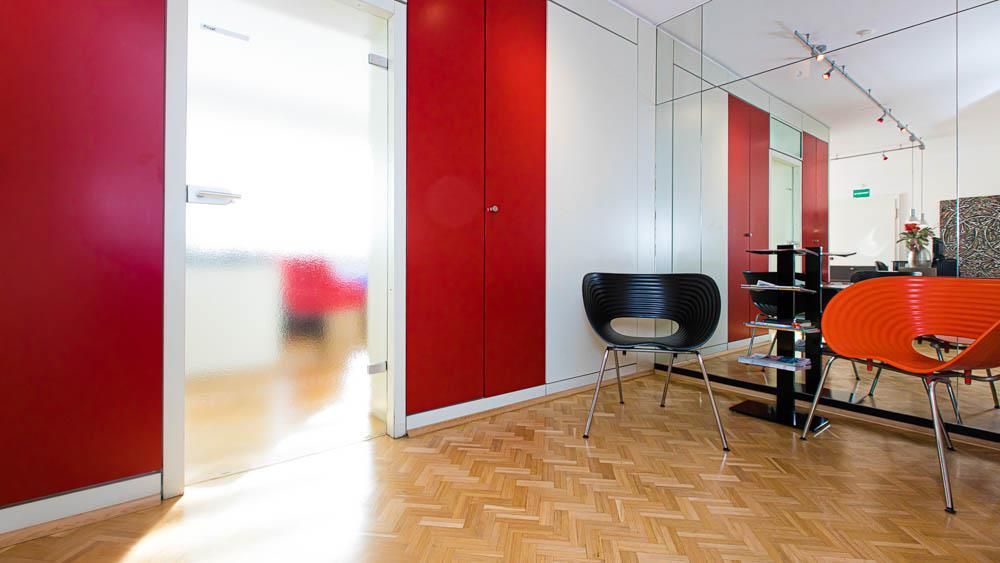 Ein Wartezimmer mit roten Wänden und Holzböden