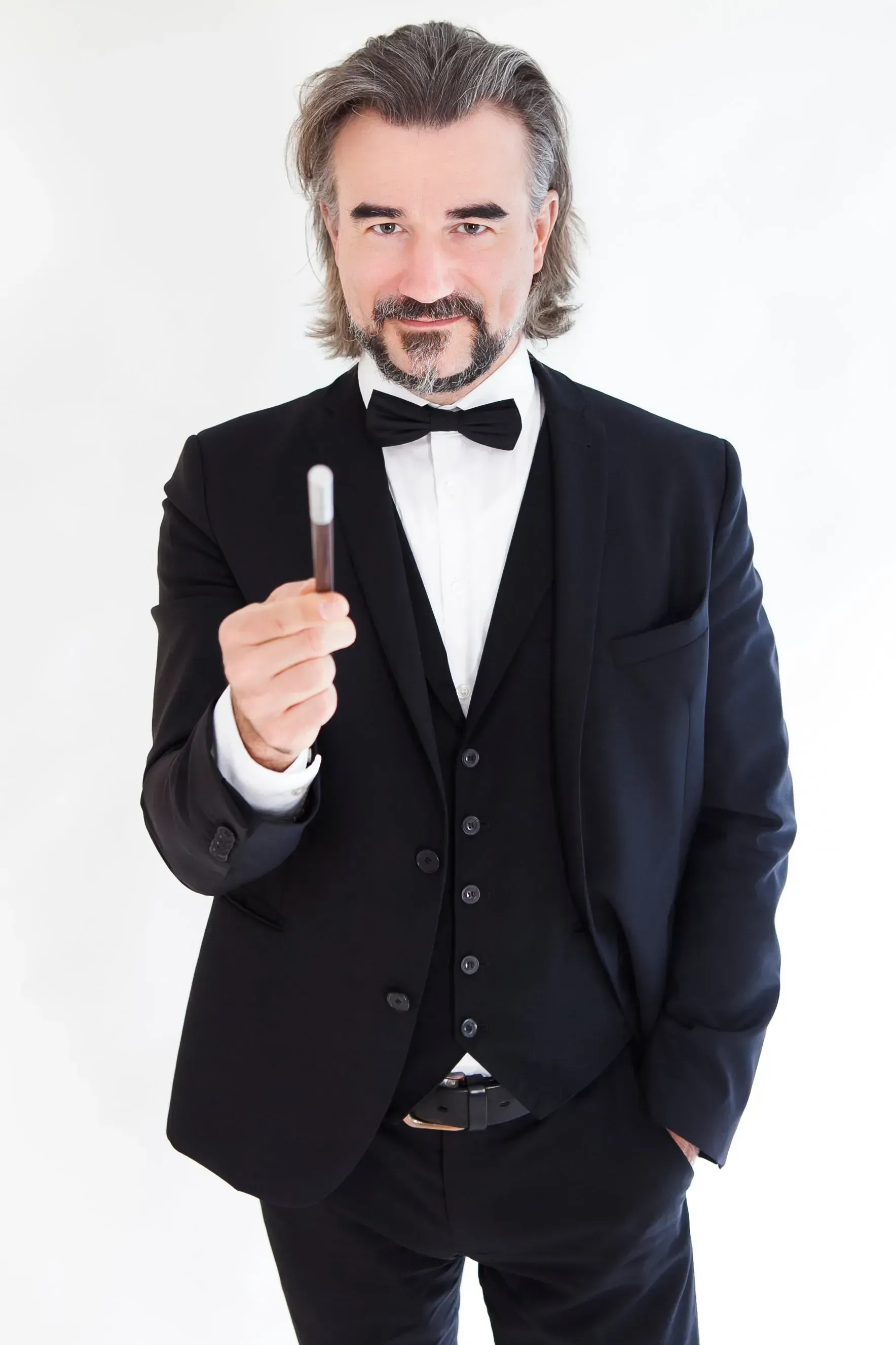 Pascal Thomas im schwarzen Smoking, der einen Zauberstab hält