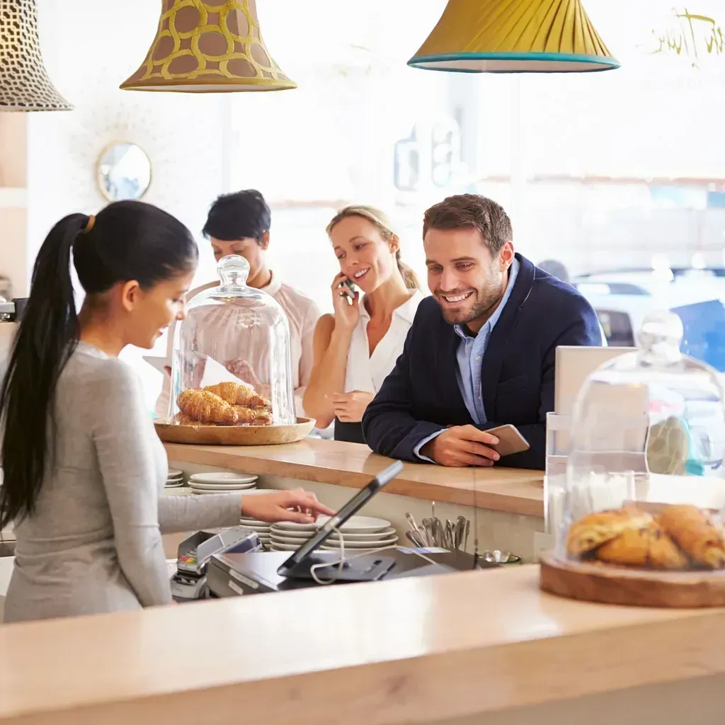 Un grupo de personas está sentada en un mostrador en un restaurante.