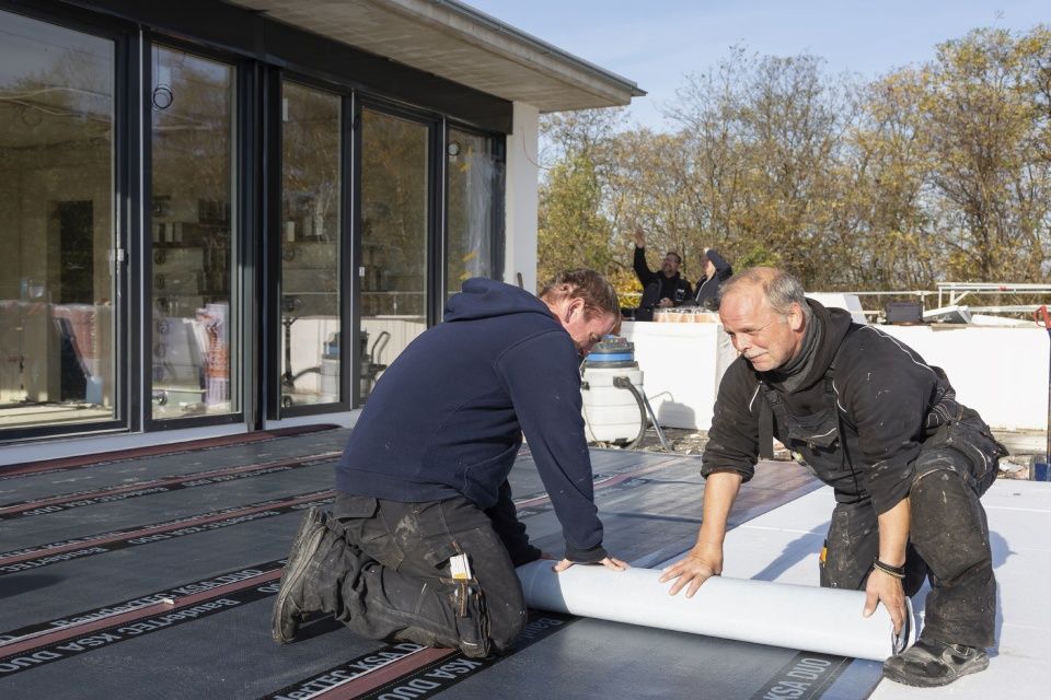 Männer arbeiten an Flachdach
