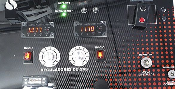 Panel de control para reguladores de gas con pantallas digitales, perillas de control redondas e interruptores iluminados sobre un fondo oscuro.