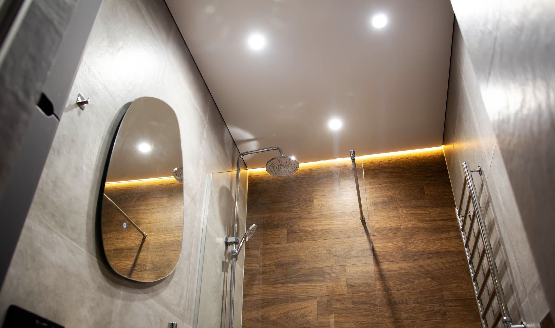 Cabine de douche moderne avec paroi texturée bois, miroir ovale, douche suspendue et éclairage encastré au plafond