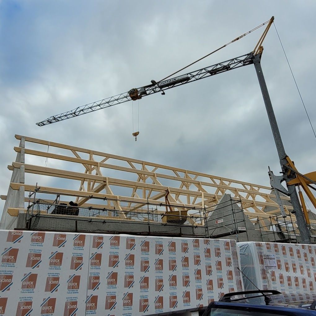 Charpente en cours de pose avec une grue
