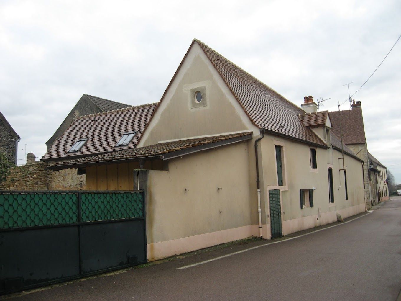 Maison ancienne avec un toit sur lequel sont installées deux fenêtres