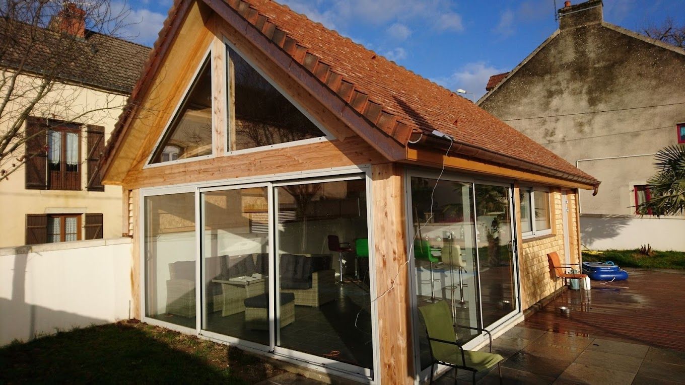 Toiture et gouttières neuves sur un bâtiment entouré de baie vitrées