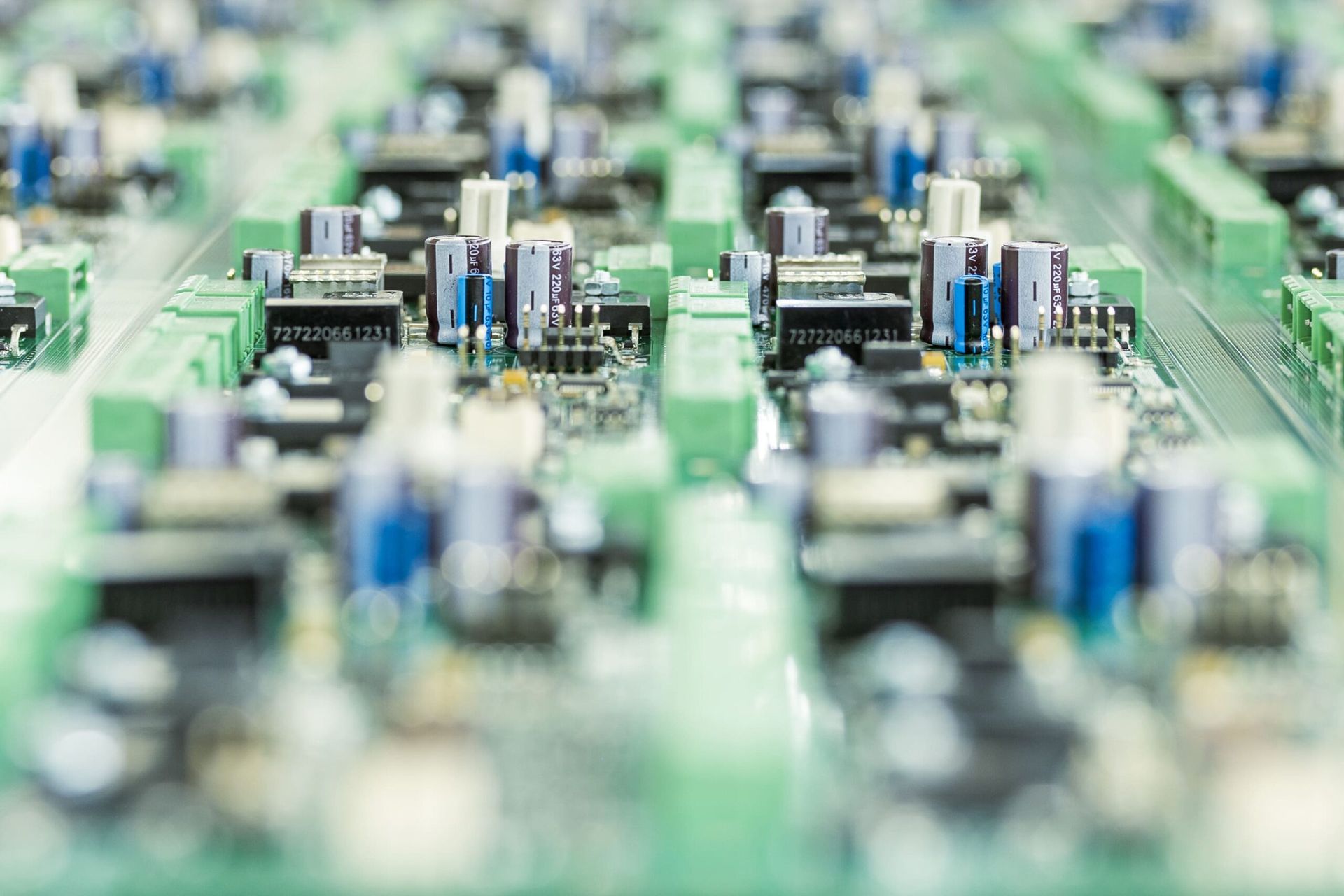 Gros plan d'une carte de circuit imprimé avec des rangées de composants électroniques et de connecteurs.