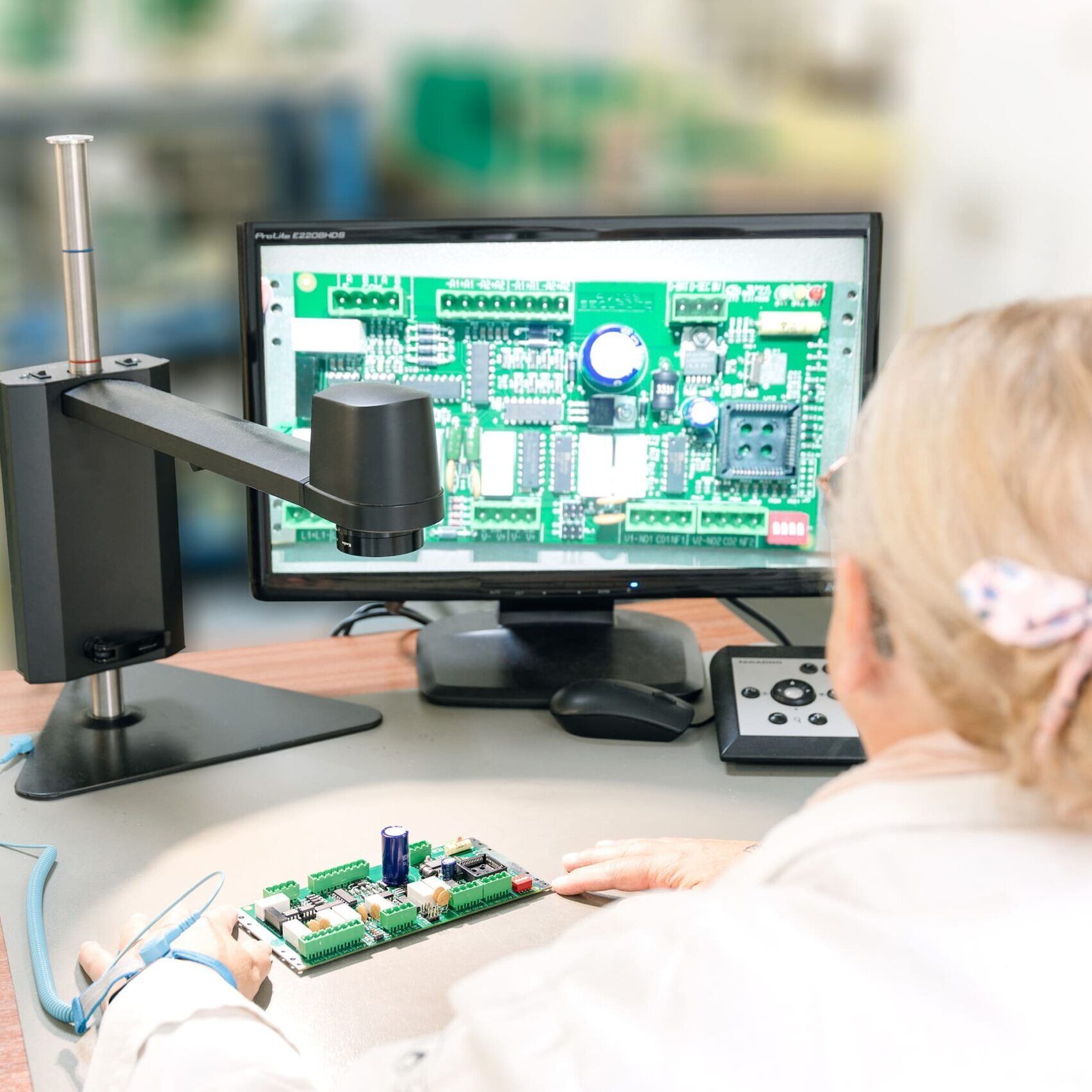 Une personne examine une carte de circuit imprimé