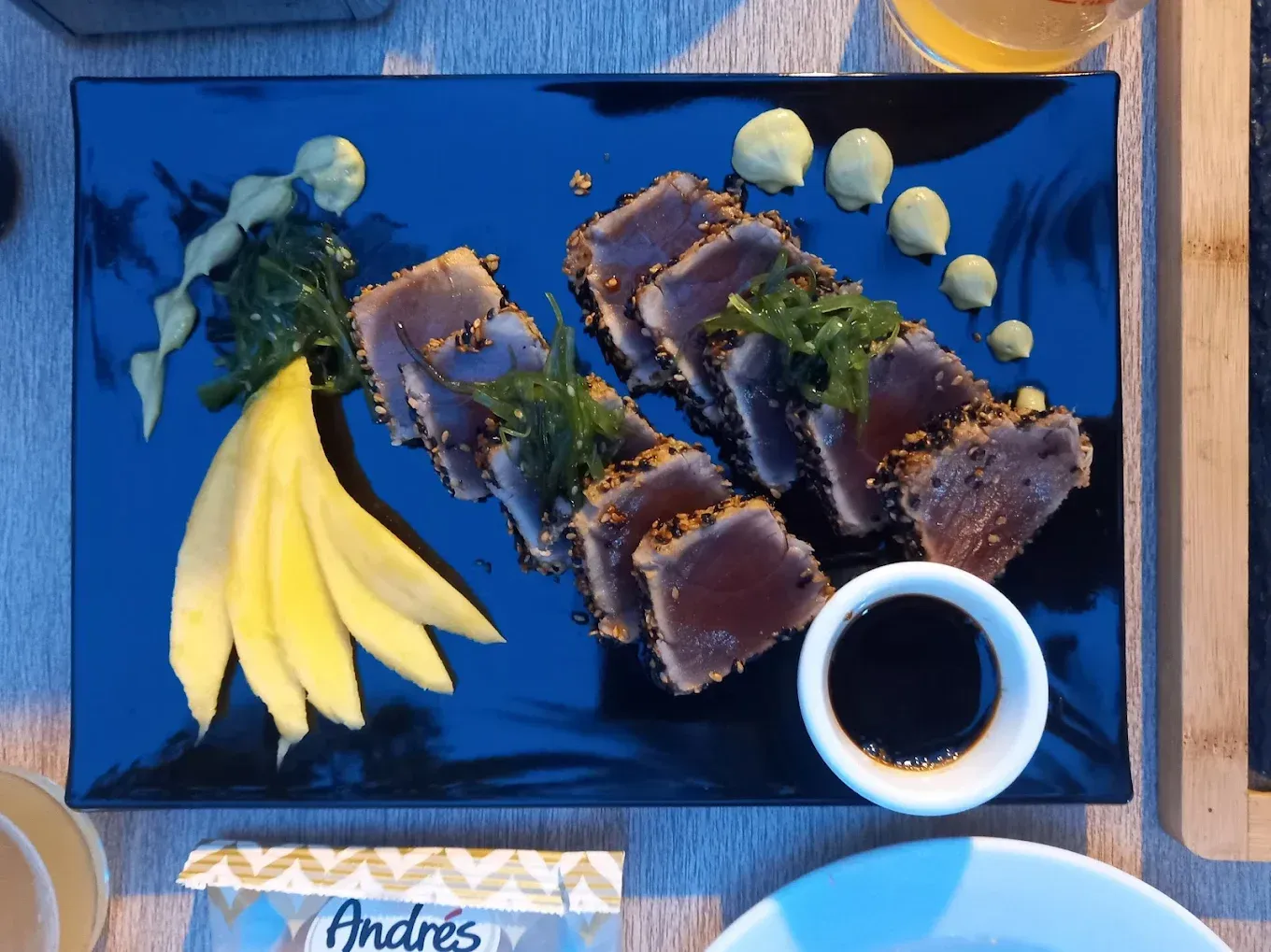Dos rollitos de primavera dorados en un plato blanco con lechuga y un tazón pequeño de salsa oscura.