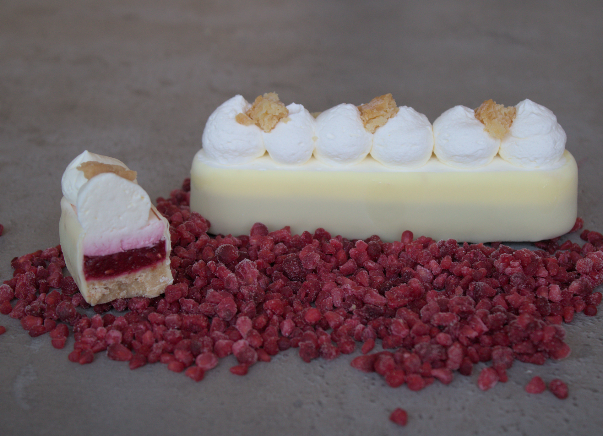 Un morceau de gâteau est posé sur un tas de framboises.