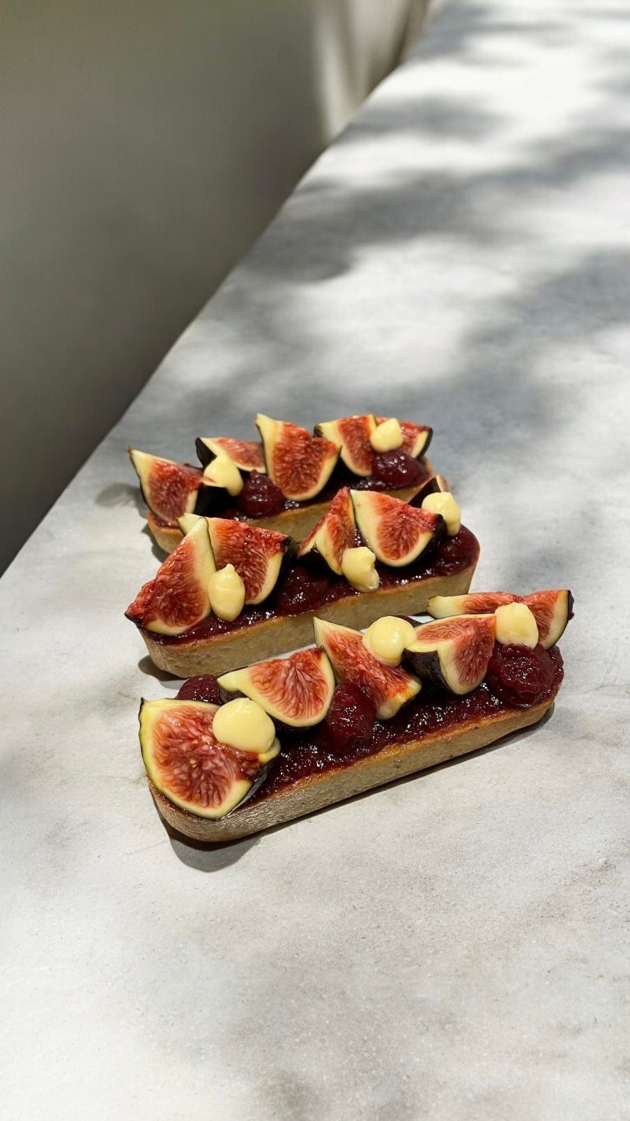 Un gros plan d'une pâtisserie aux figues et à la crème sur une table.