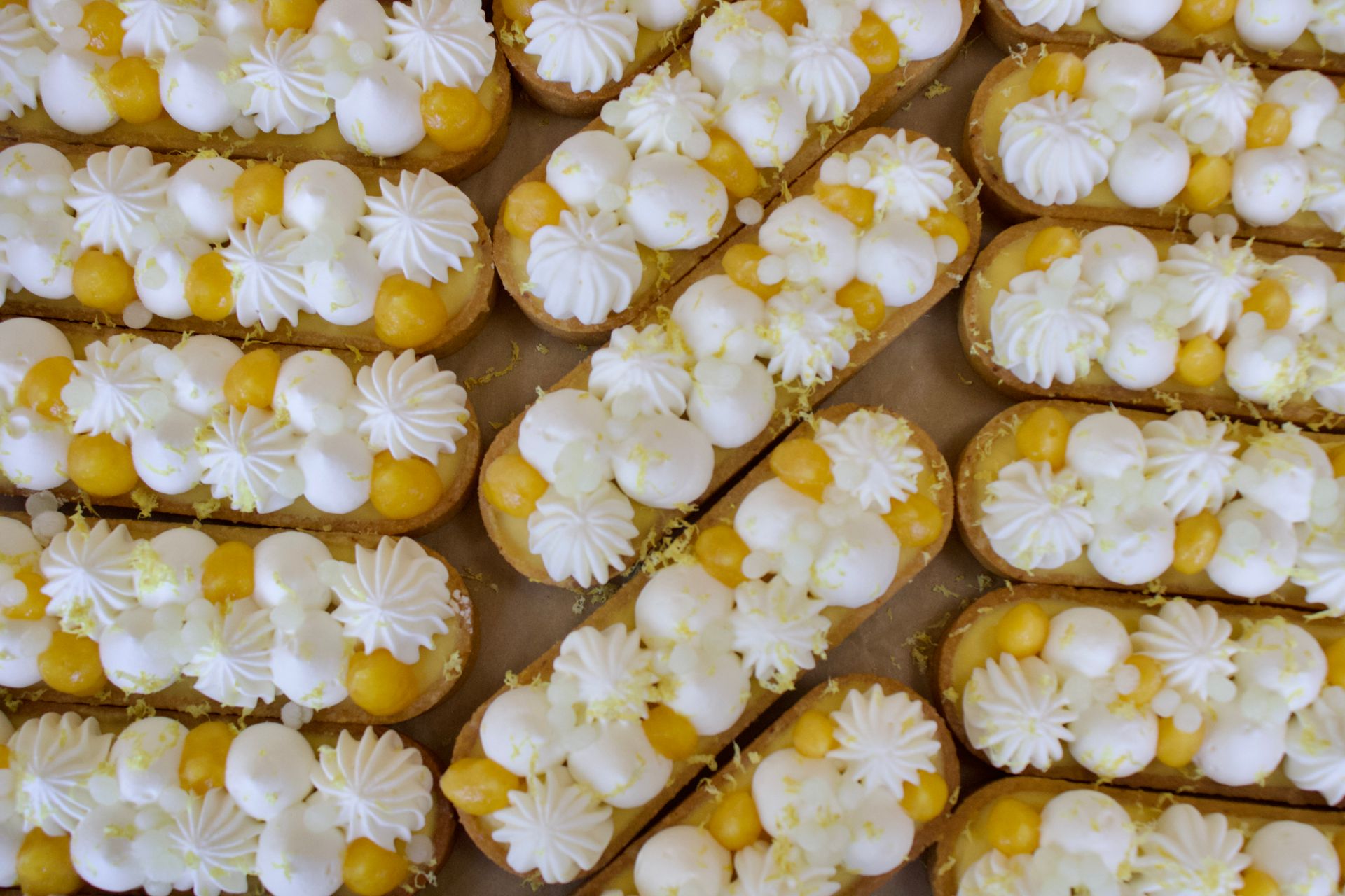 Un bouquet de desserts avec du glaçage jaune et blanc sur une table.