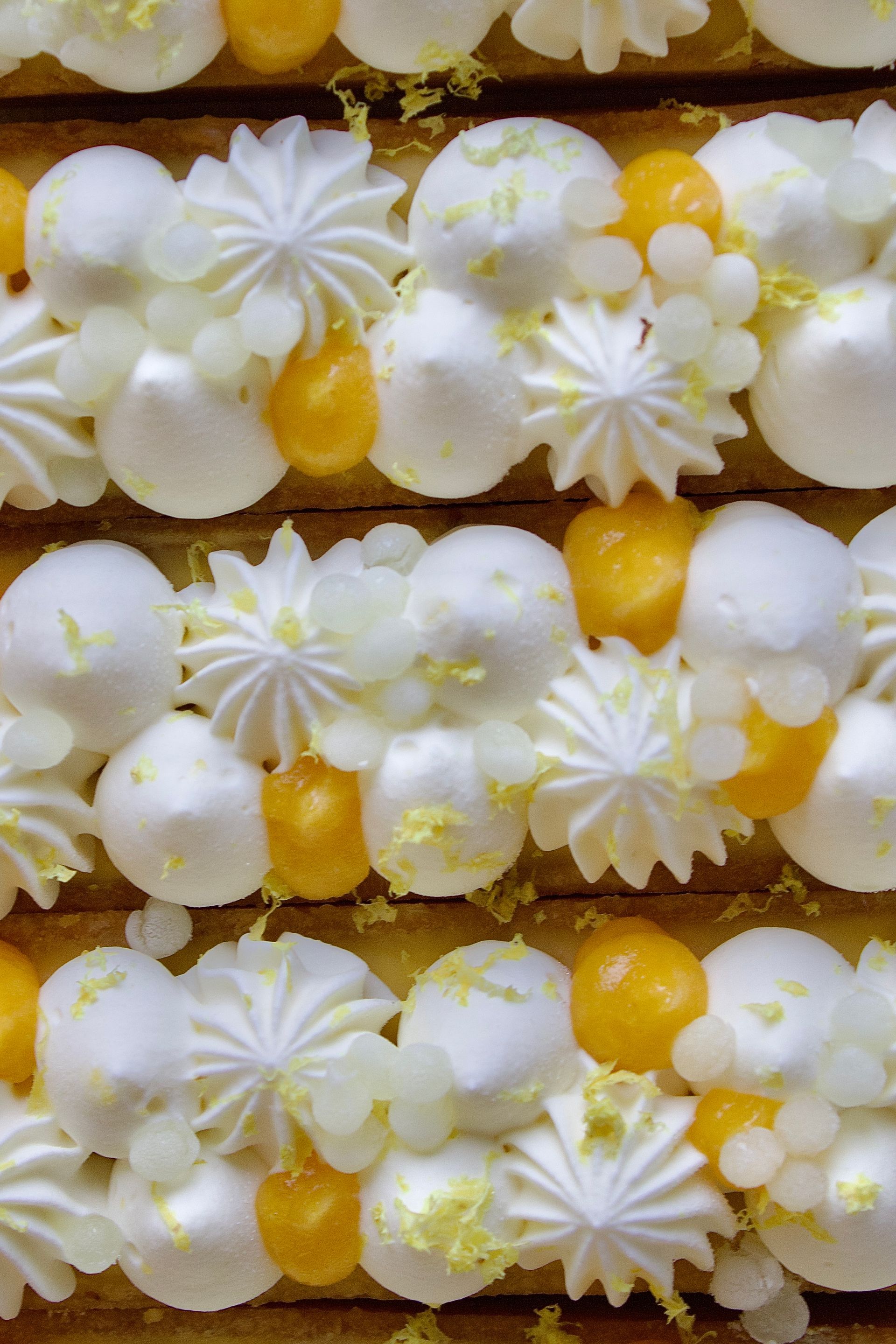 Un gros plan d'un gâteau avec un glaçage jaune et blanc
