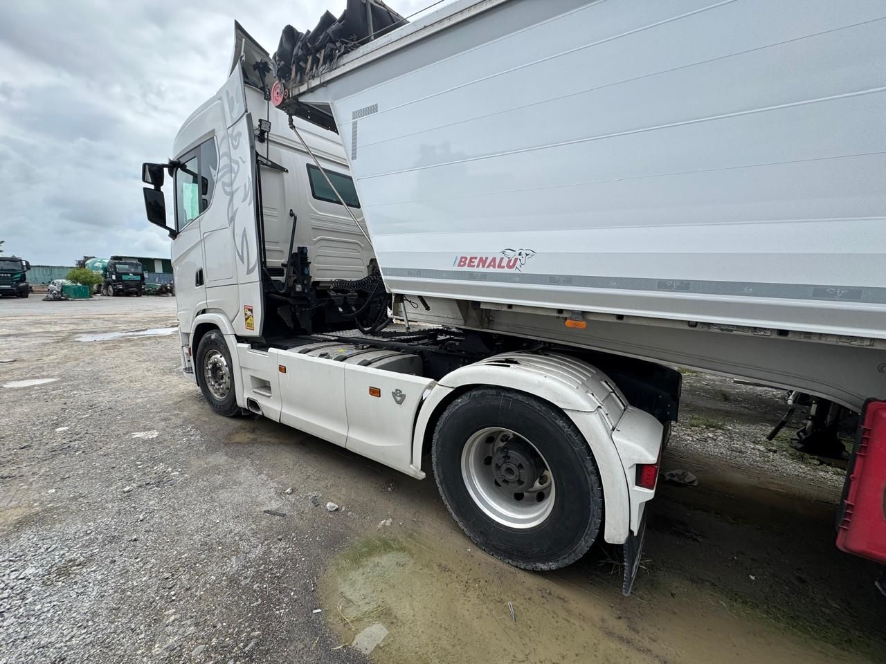 Camion-benne blanc sur fond orange.