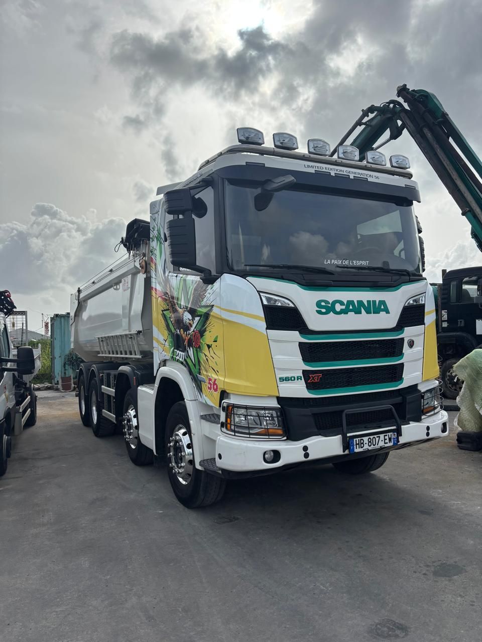 Un semi-remorque blanc sur une route au coucher du soleil, projetant une lumière dorée.