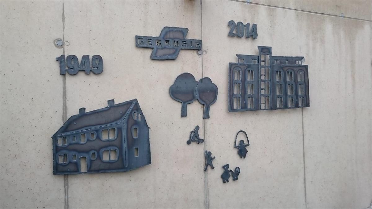 Eine Wand mit einer Zeichnung eines Hauses und eines Gebäudes und der Jahreszahl 1949