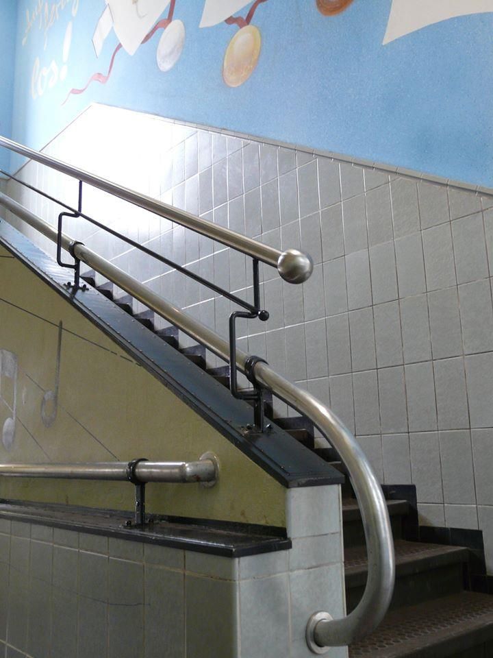 Eine Treppe mit einem Metallgeländer und einem Wandgemälde an der Wand