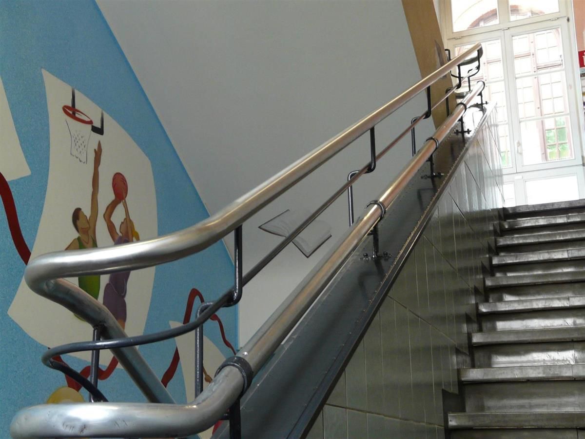 Eine Treppe mit Geländer und einem Wandgemälde an der Wand