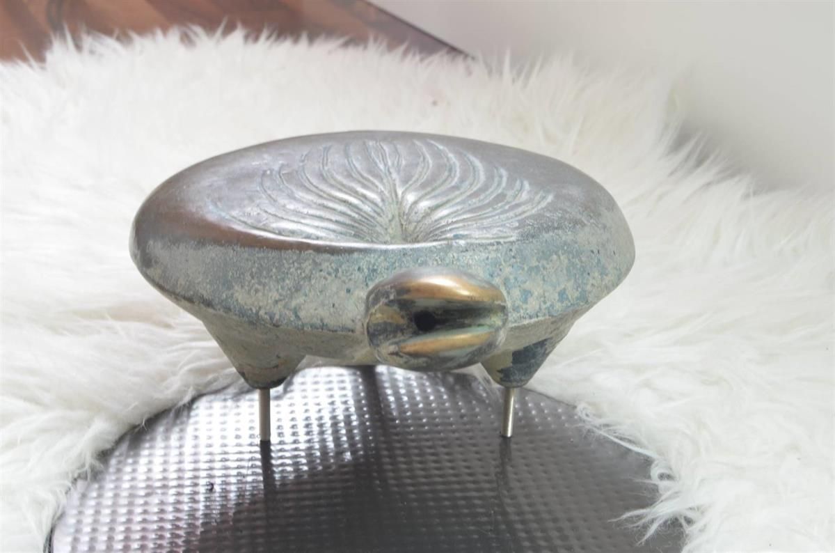 Eine Statue eines Frosches sitzt auf einer weißen Decke