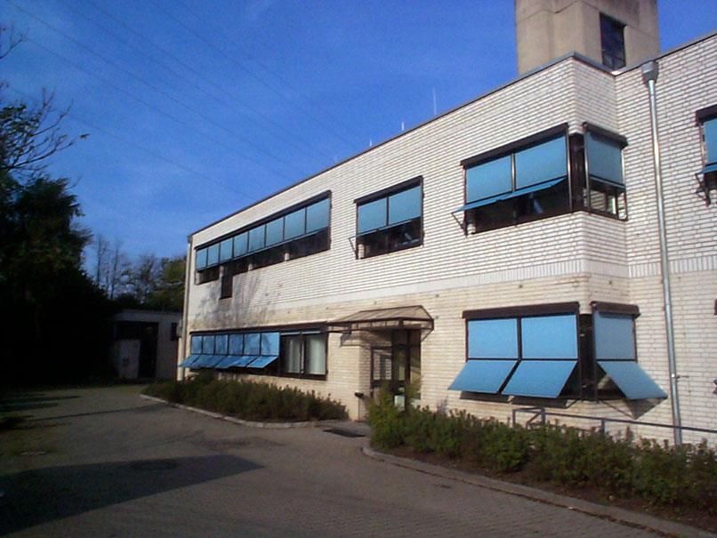 Ein weißes Gebäude mit blauen Jalousien an den Fenstern