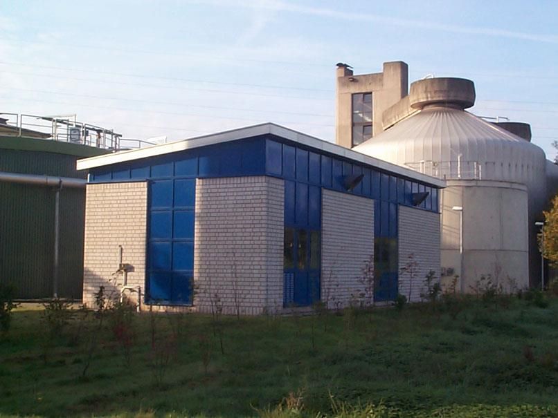 Ein Gebäude mit blauem Dach steht inmitten einer Wiese