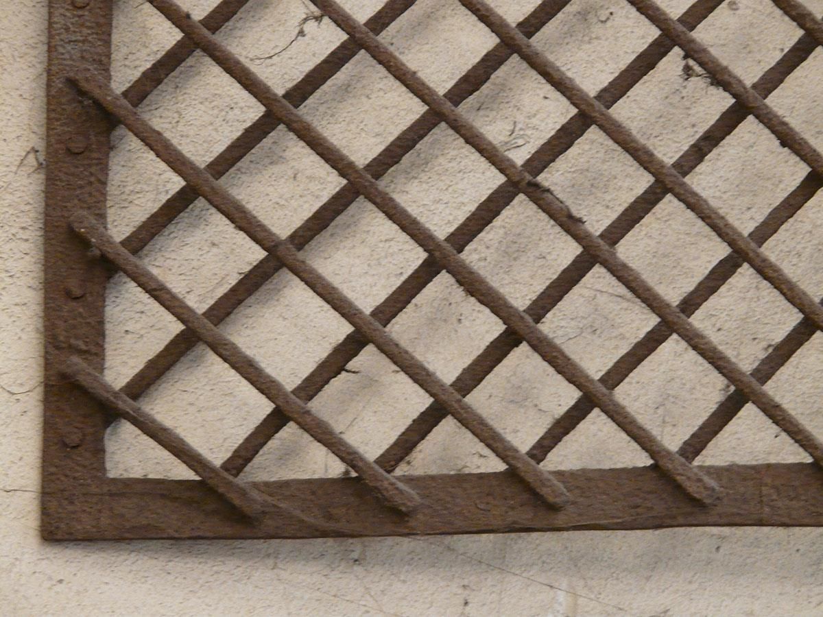 Eine Nahaufnahme eines Metallgitters an einer Wand