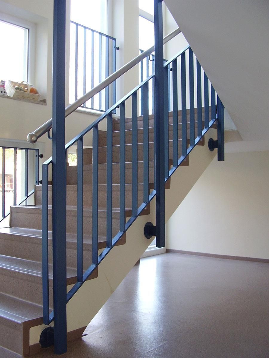 Eine Treppe mit blauem Geländer in einem leeren Raum