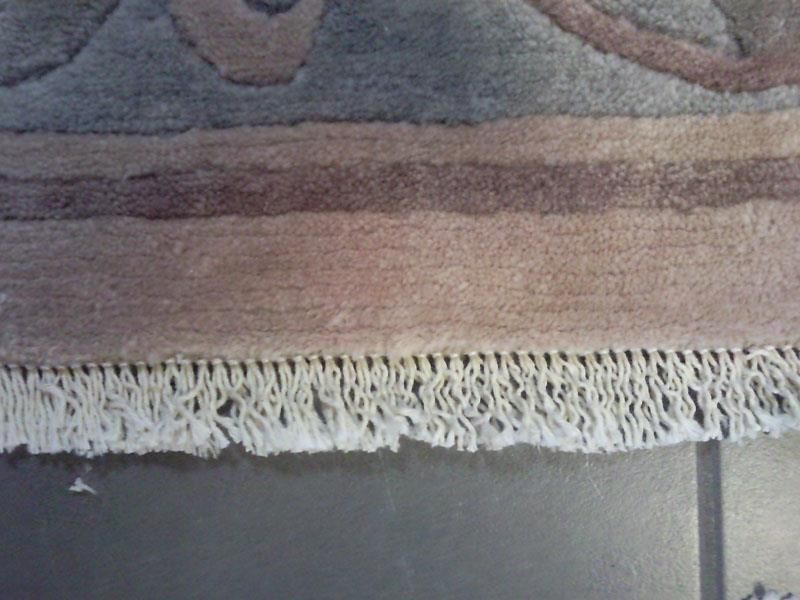 Eine Nahaufnahme eines Teppichs mit Fransen