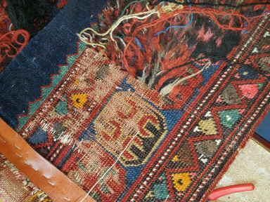 Eine Nahaufnahme eines Teppichs, der auf einem Tisch repariert wird.