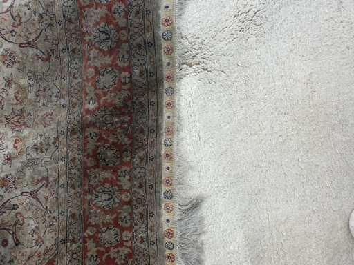 Ein weißer Teppich liegt neben einem roten Teppich.