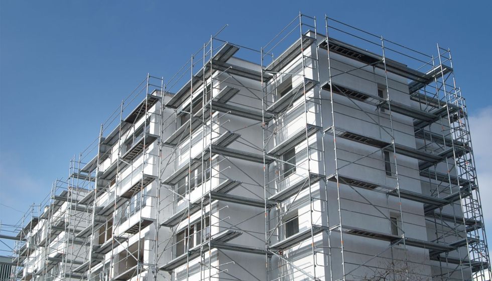 Un andamio está situado delante de un edificio de ladrillos.